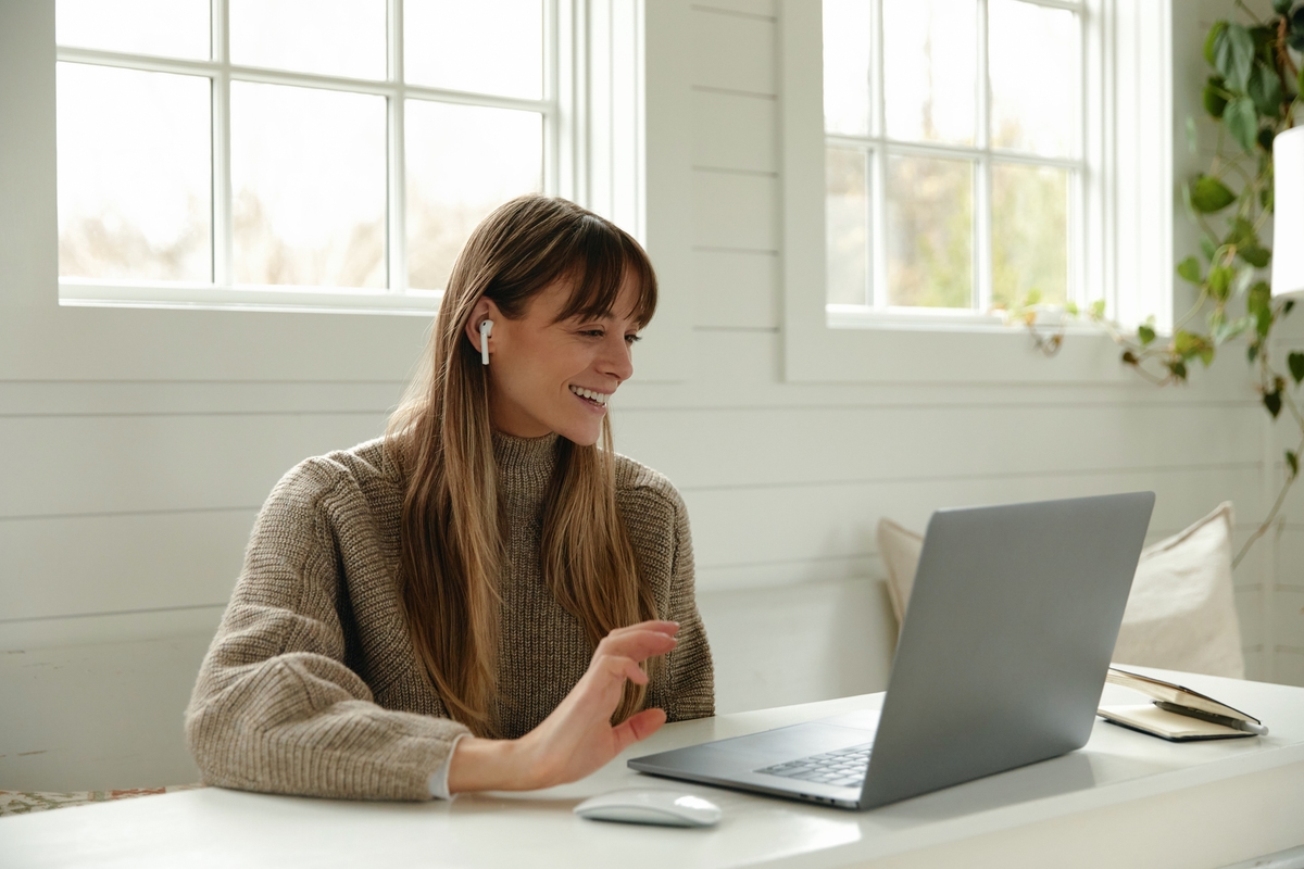 Blonde woman smiling at laptop