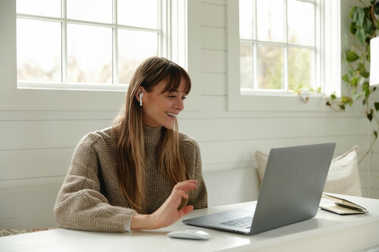 Blonde woman smiling at laptop